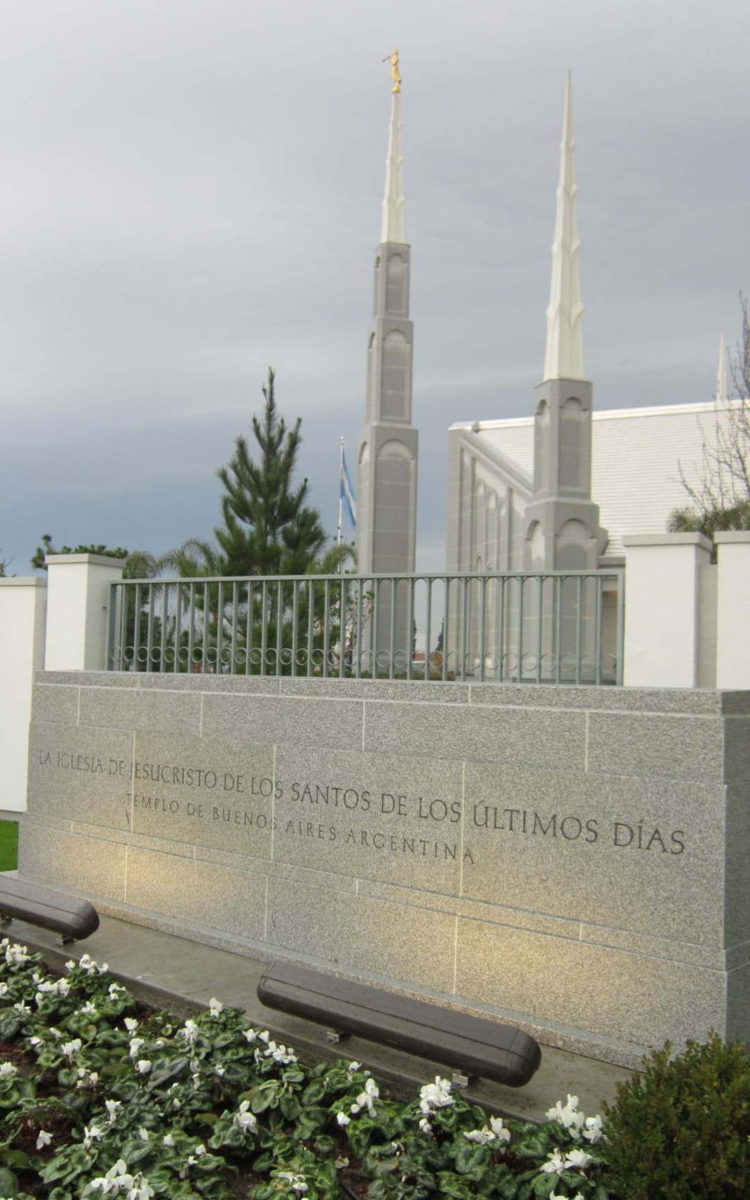 Fasad elegan bait suci dengan granit abu-abu muda dan jendela melengkung.