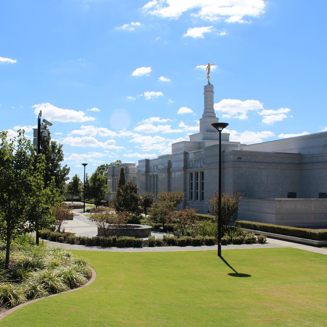 Exterior view of Perth Australia Temple with Angel Moroni and gardens.