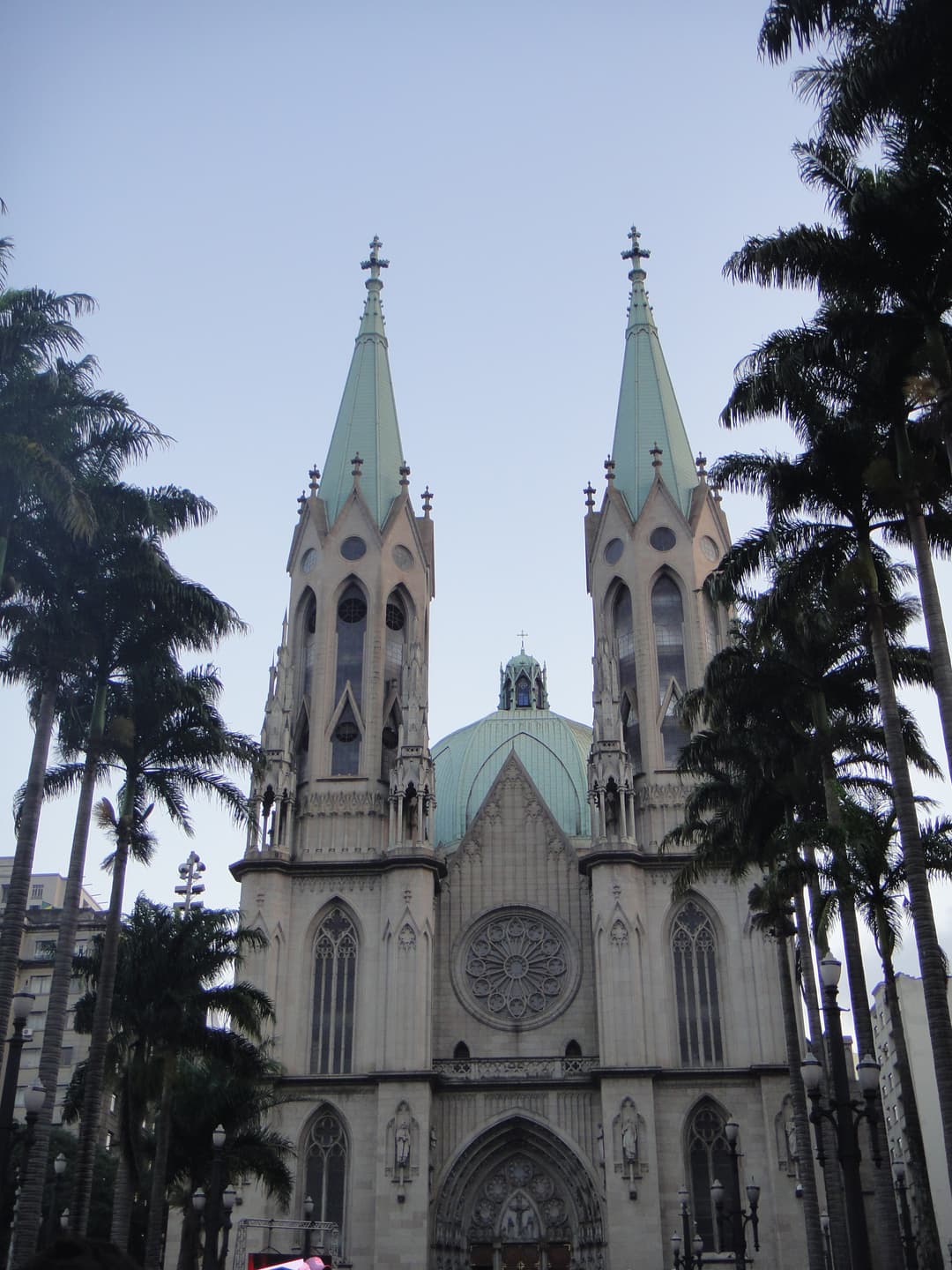 Front facade of Catedral da Sé framed by palm trees.