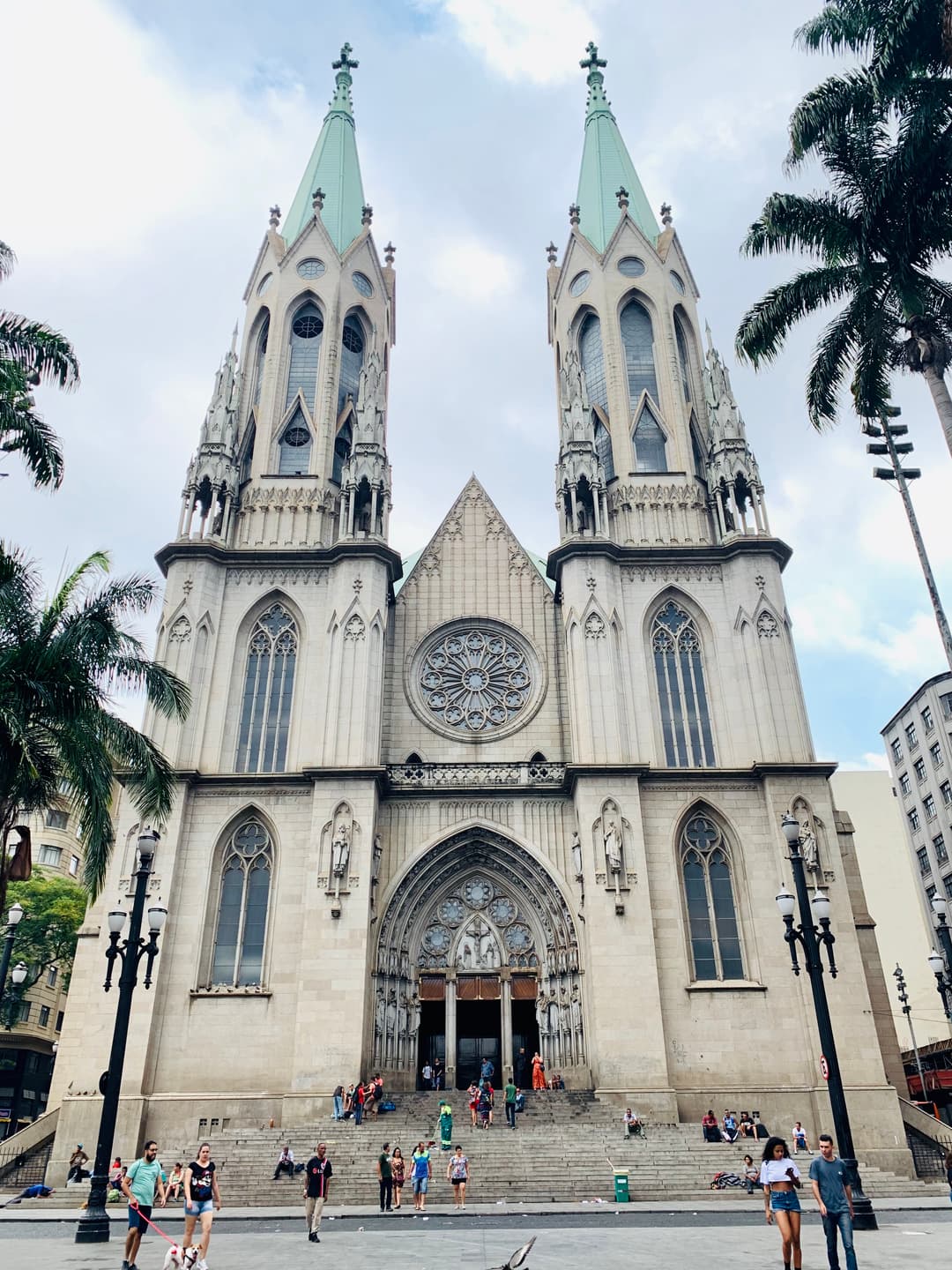 Daytime front facade view of Catedral da Sé with twin spires and steps.