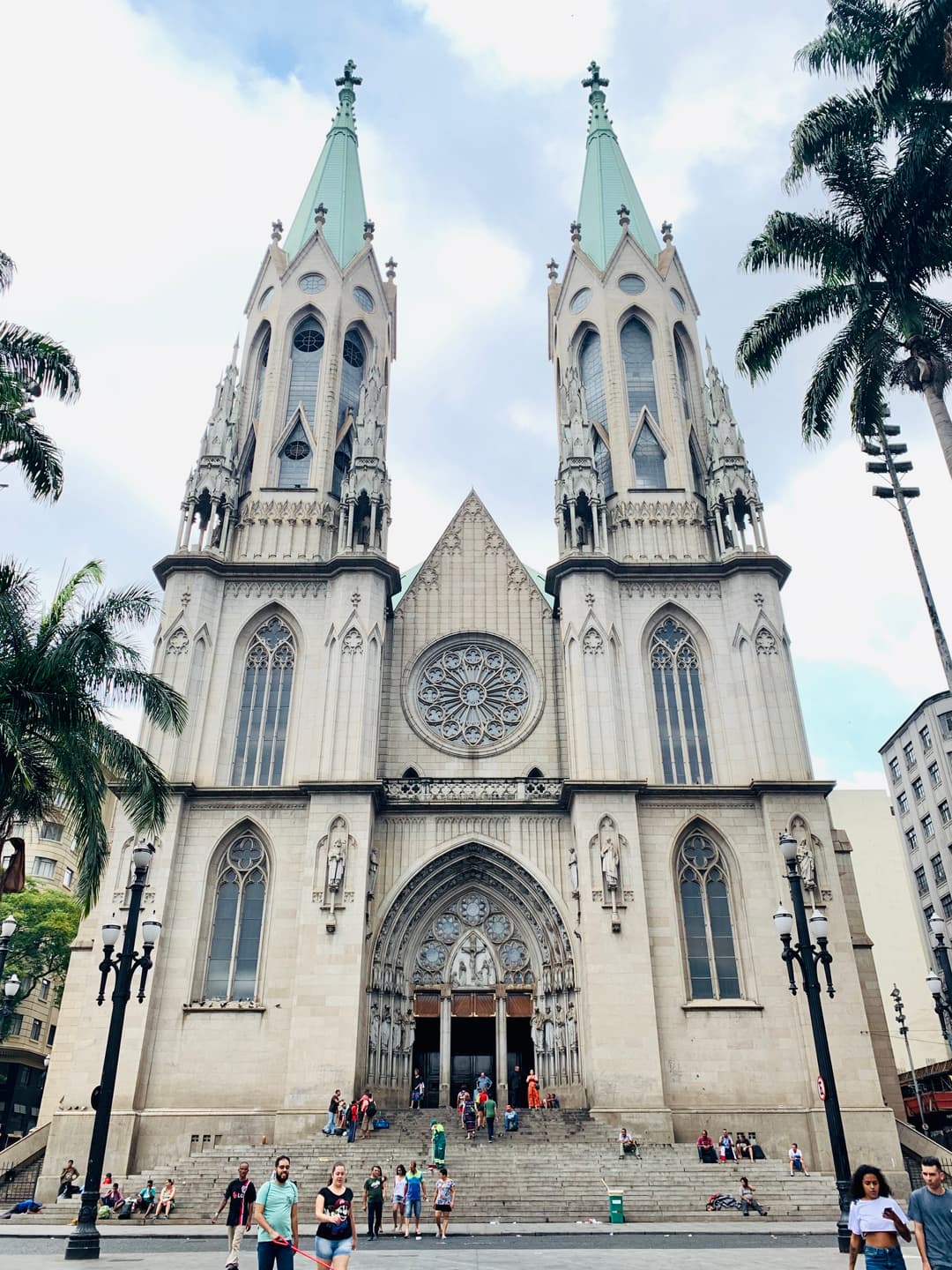 Front exterior facade of Catedral da Sé featuring its twin green spires.