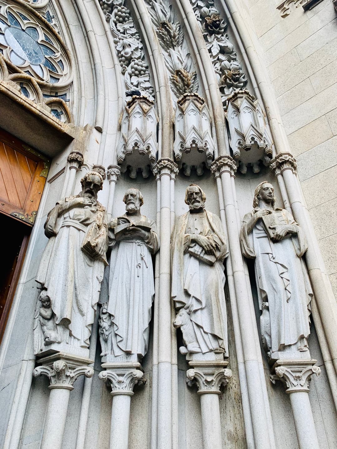 Exterior detail of carved evangelist statues at the portal of Catedral da Sé.