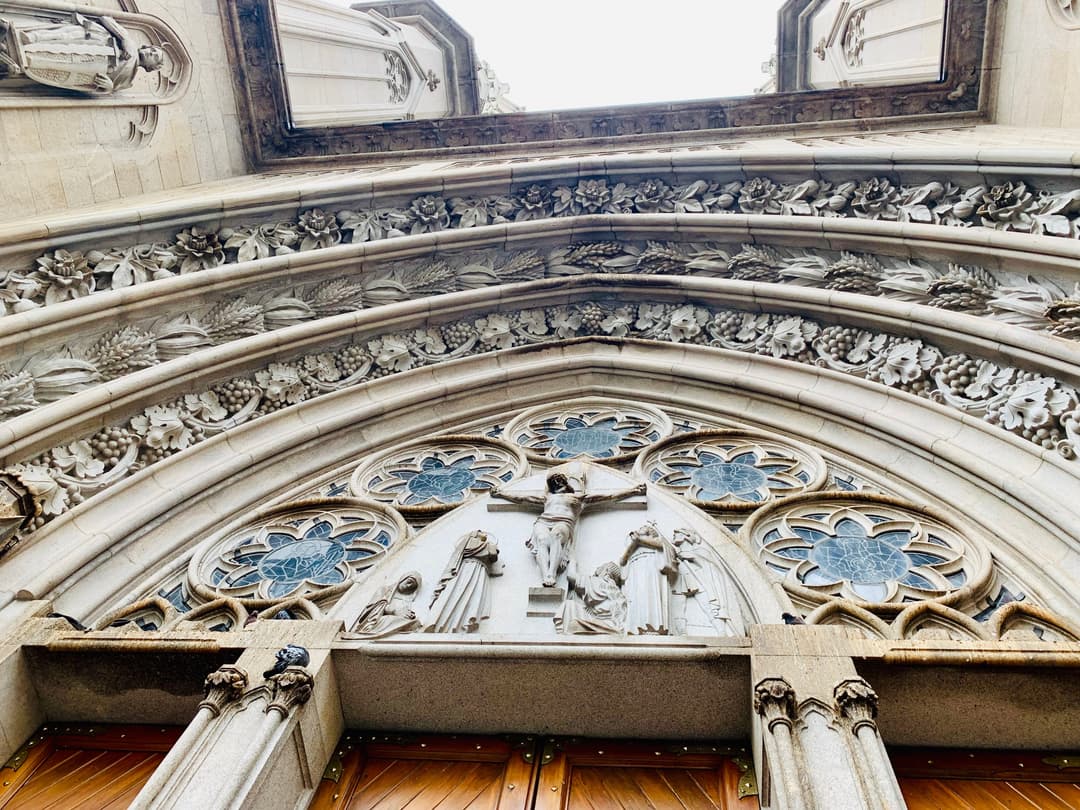 Low-angle detail of the carved entrance portal and Crucifixion tympanum.