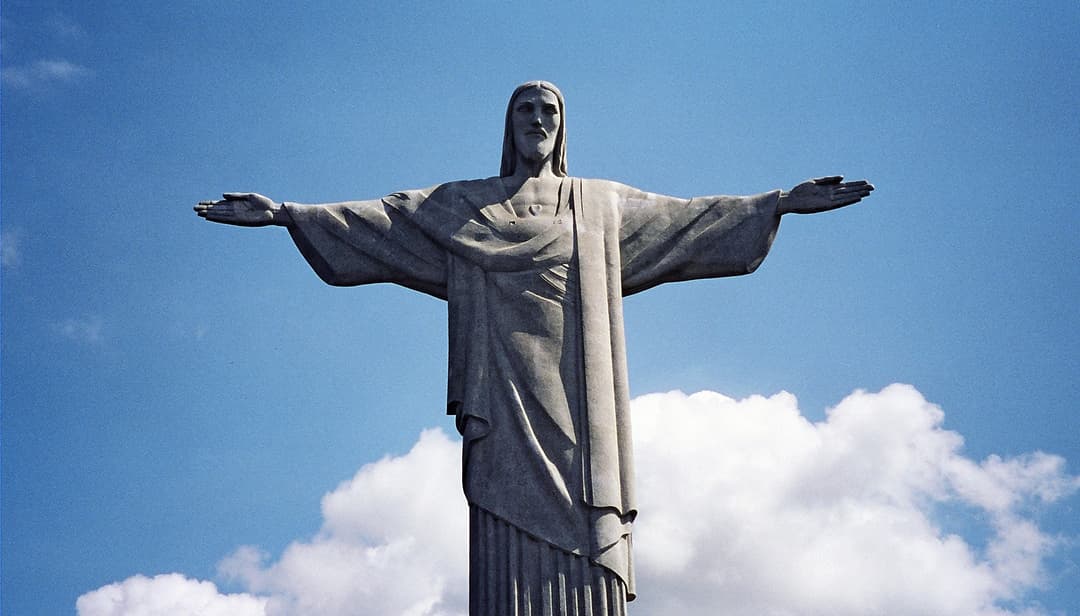 Front view of the Christ the Redeemer statue against a blue sky.