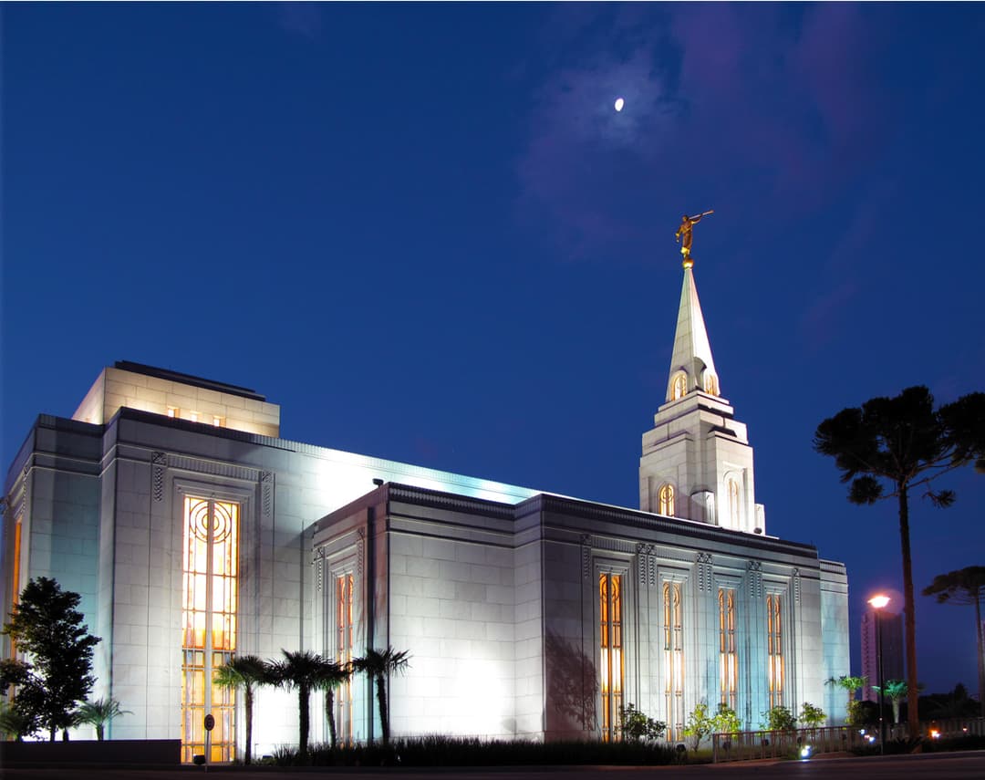 The illuminated Curitiba Brazil Temple at night under a glowing moon.