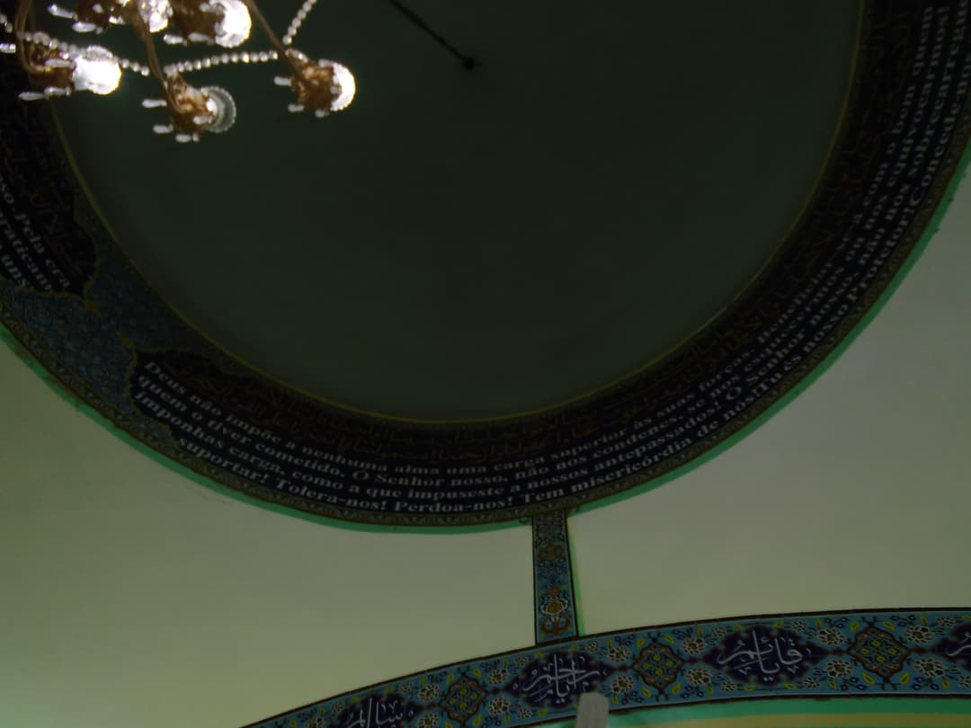 Interior view of the dome base with calligraphic frieze and chandelier.