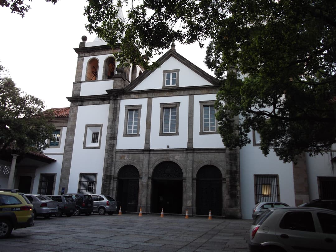 Exterior view of the historic monastery facade and paved courtyard.