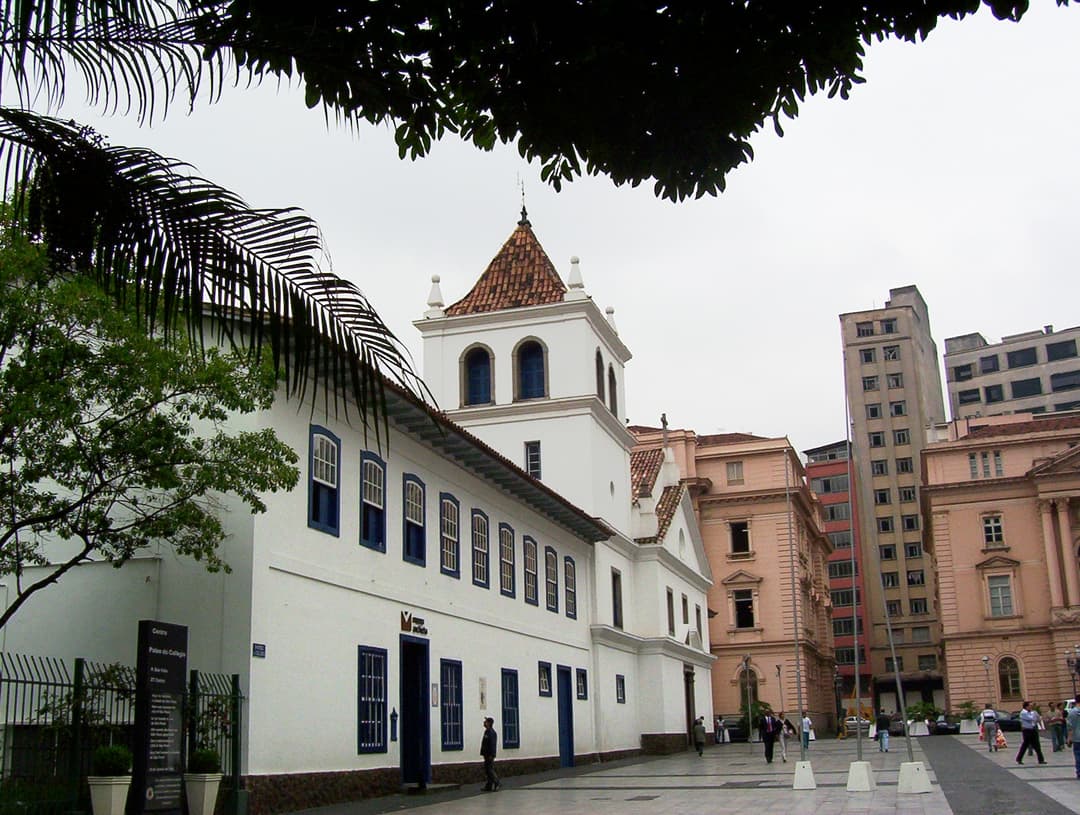 Angled exterior view of the Pátio do Colégio facade and bell tower.