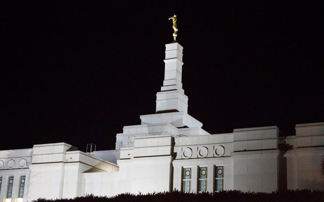 The illuminated spire of the Porto Alegre Brazil Temple at night.