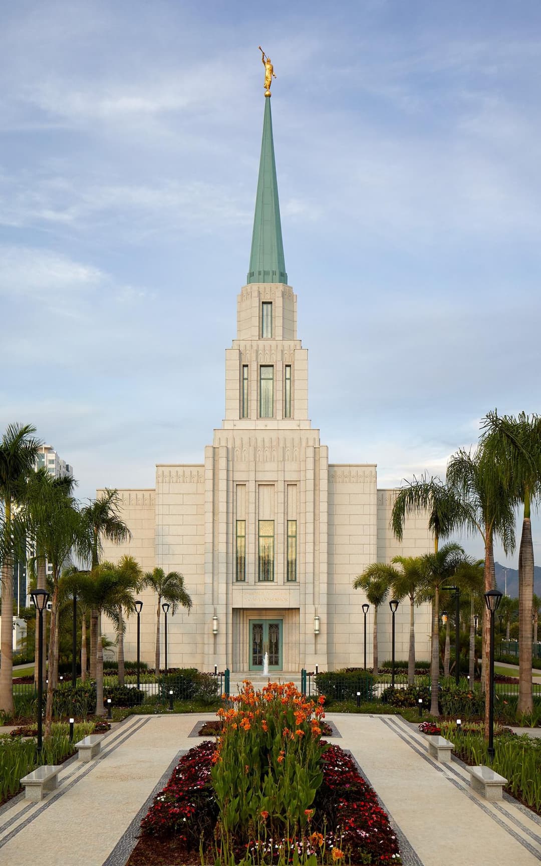 Daytime front view of the main entrance, spire, and landscaped grounds.