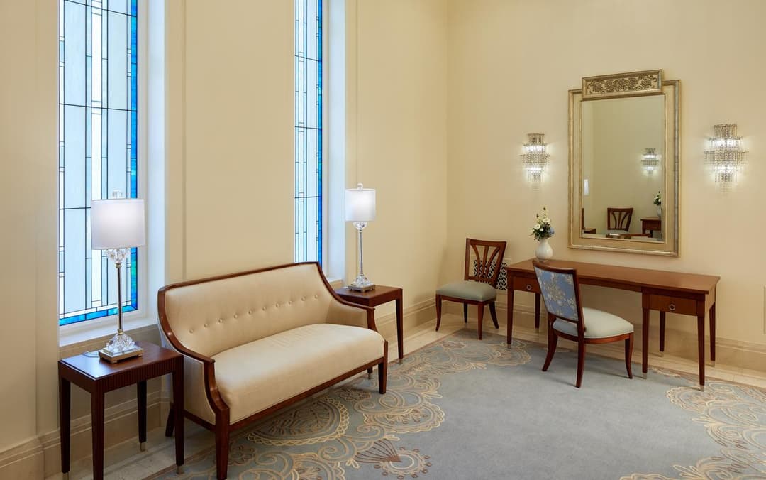 Bride's room featuring a vanity, sofa, and stained glass windows.
