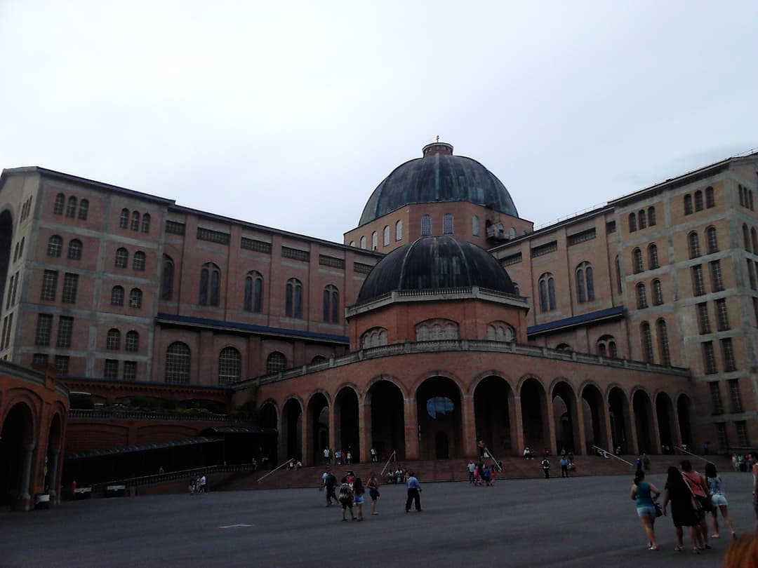 Exterior wide view of the main facade, brick arcade, and central domes.