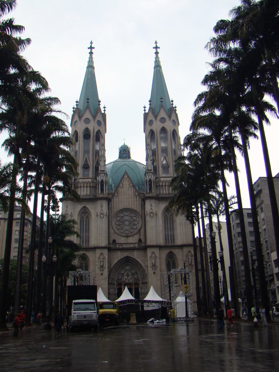 São Paulo Cathedral exterior, framed by palm trees on a cloudy day.