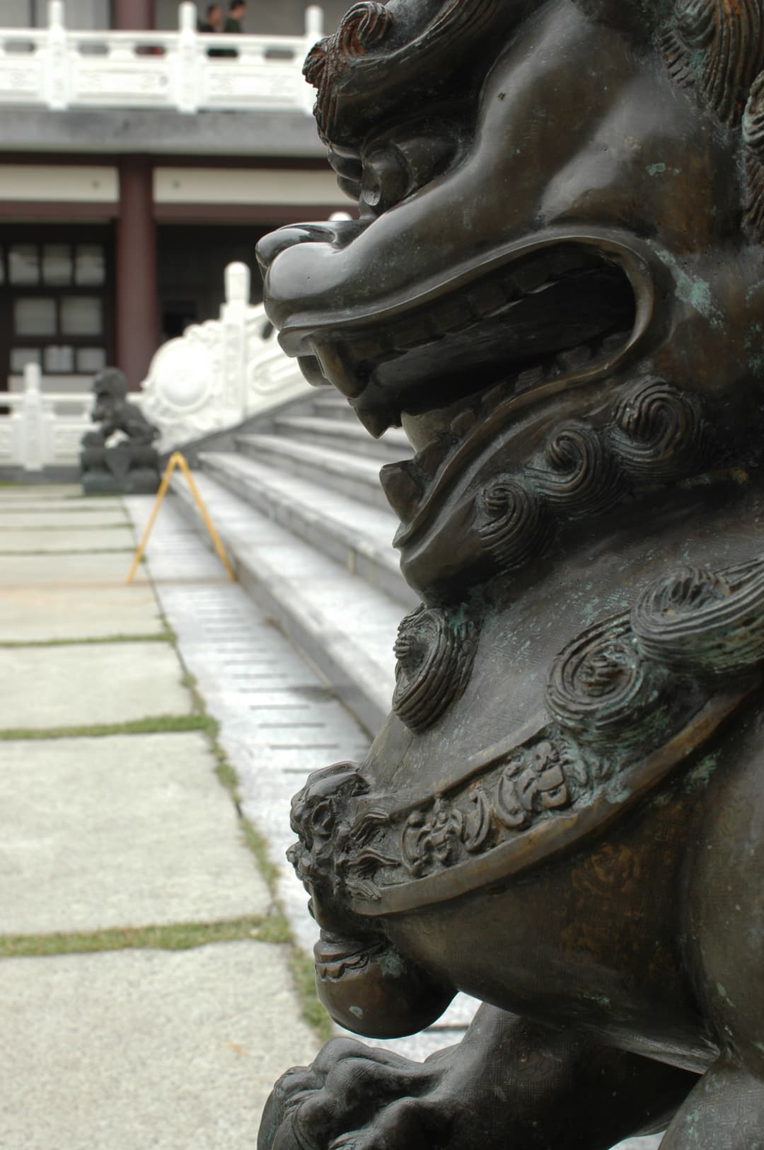 Close-up of a bronze guardian lion statue by the stairs at Templo Zu Lai.