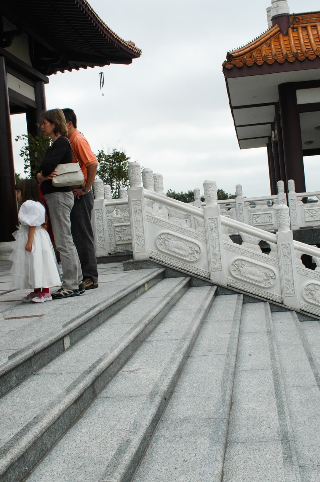 Visitors on the carved white granite stairs at Templo Zu Lai.
