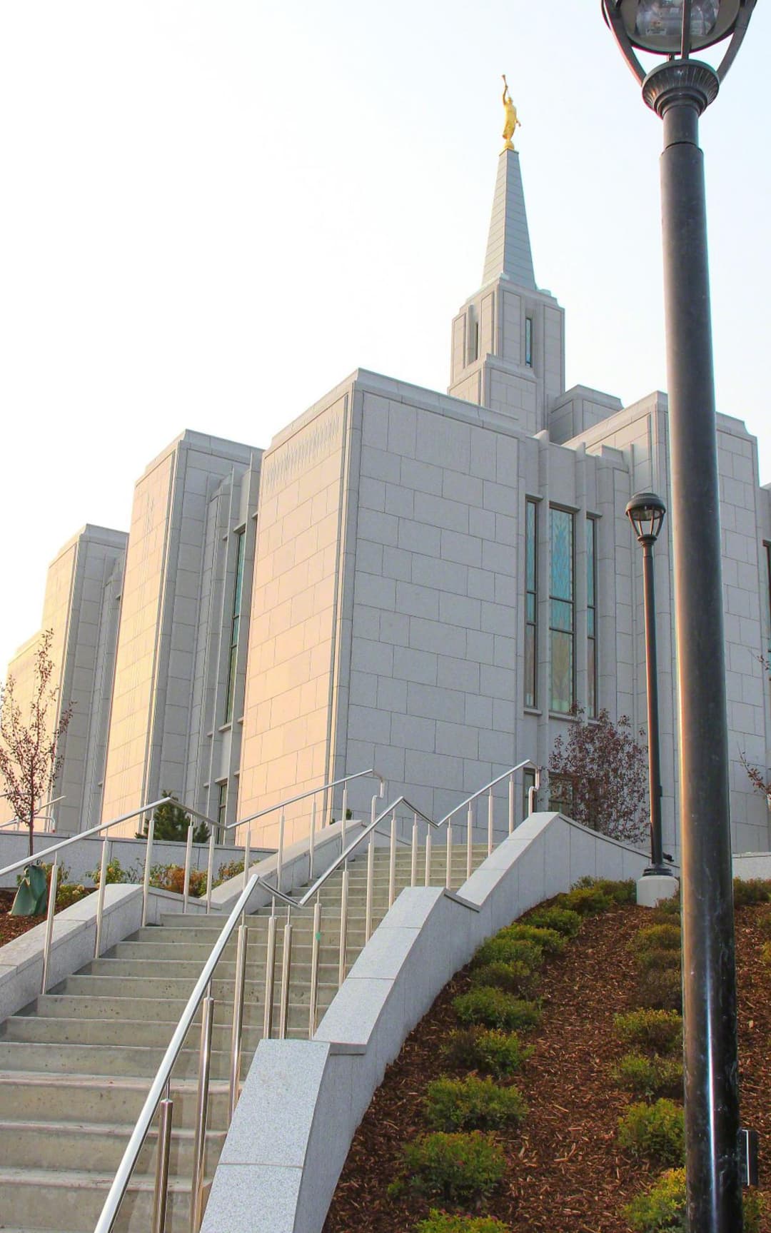Pemandangan sudut rendah tangga dan menara Calgary Alberta Temple dalam cahaya hangat.