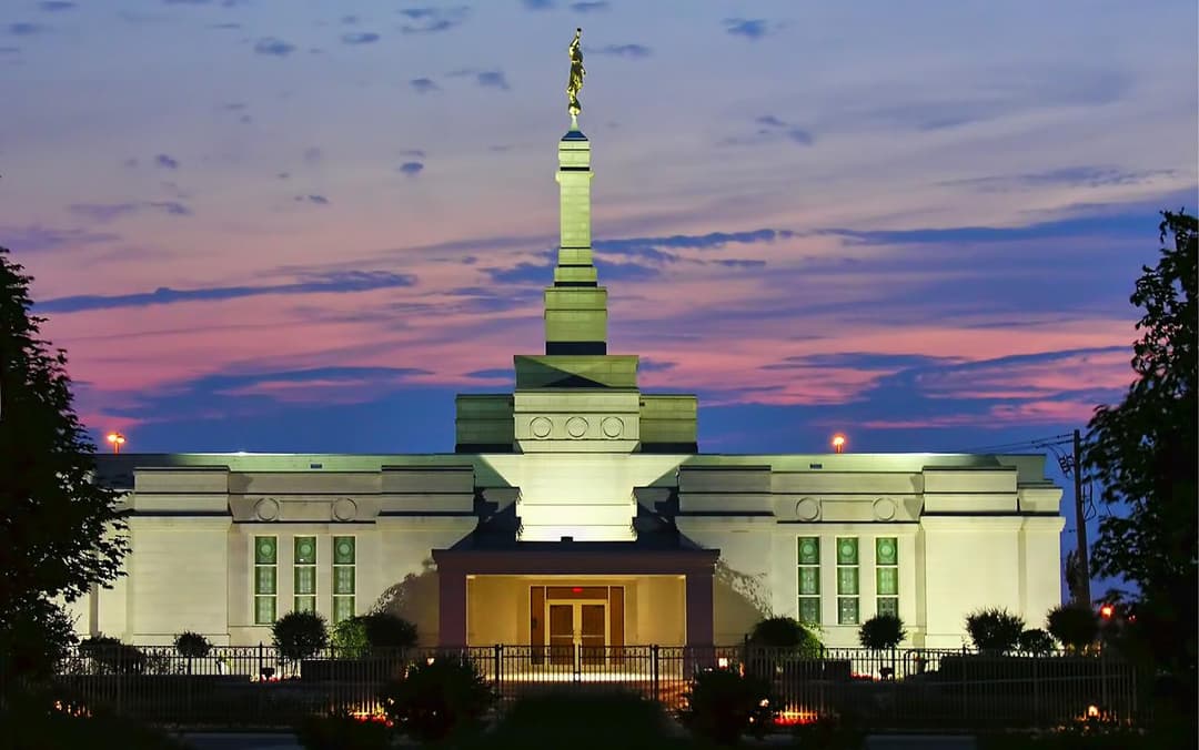 Montreal Quebec Temple at twilight, illuminated, with Moroni statue.