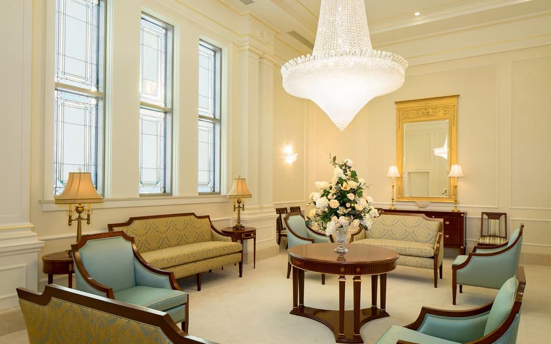 Elegant interior lounge with chandelier, mirror, and patterned seating.