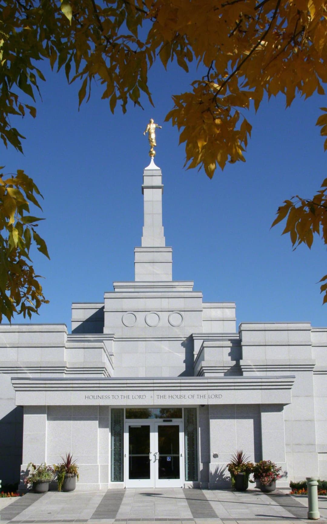 Front entrance of the Regina Saskatchewan Temple framed by autumn leaves.