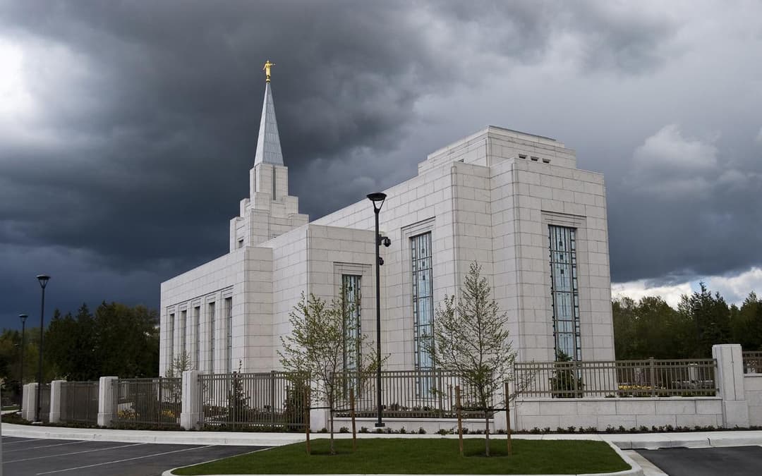 Exterior view of the Vancouver British Columbia Temple under dark storm clouds.
