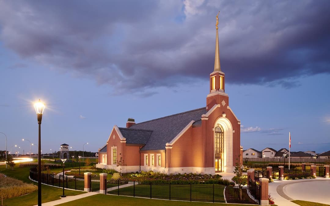Exterior of the Winnipeg Manitoba Temple illuminated at twilight.