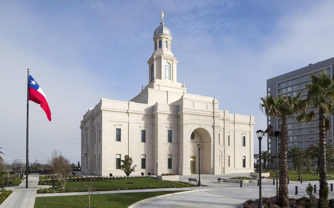 Daytime exterior of the Concepción Chile Temple and Chilean flag.