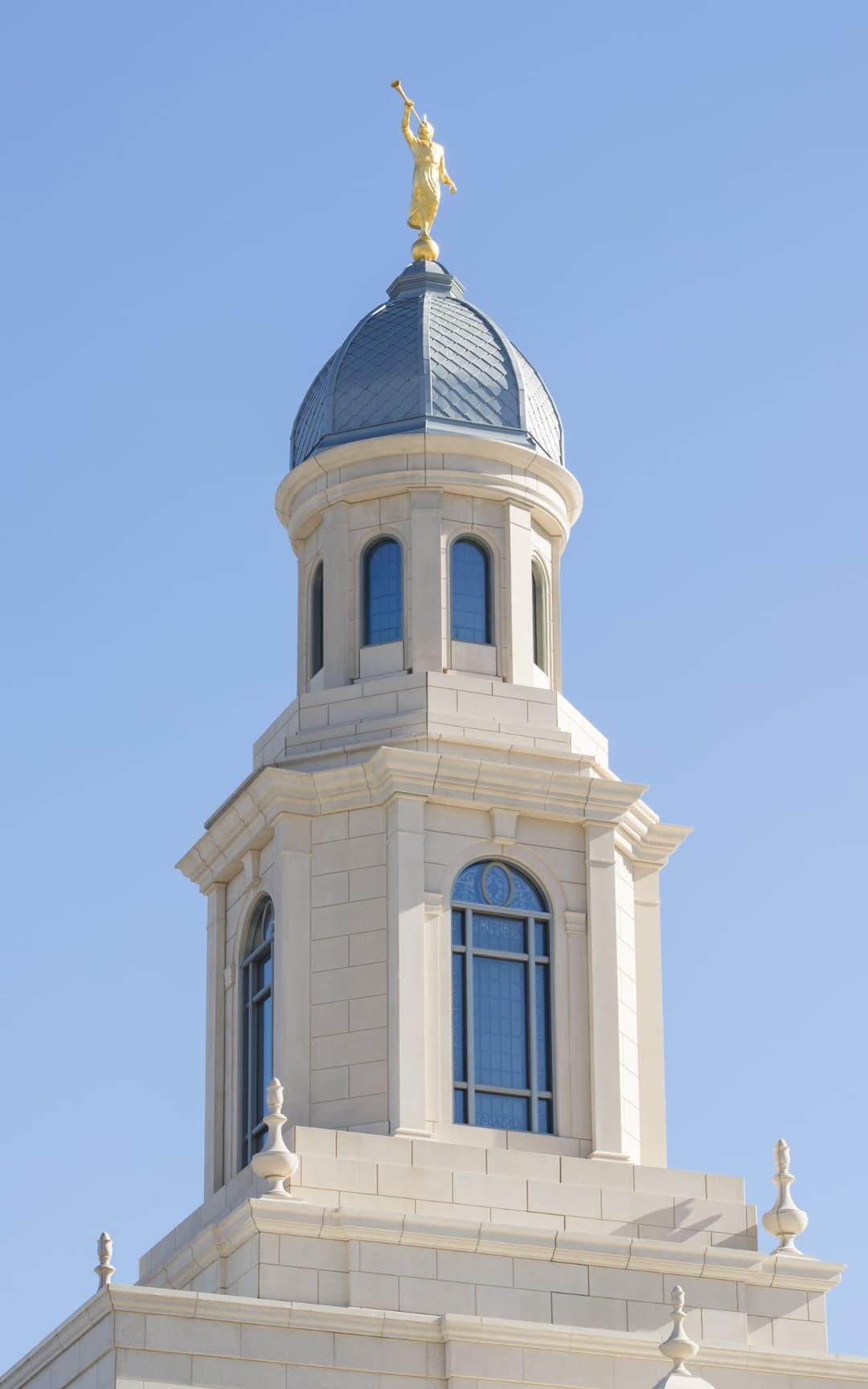 Low-angle daytime close-up of the dome tower and Angel Moroni statue.