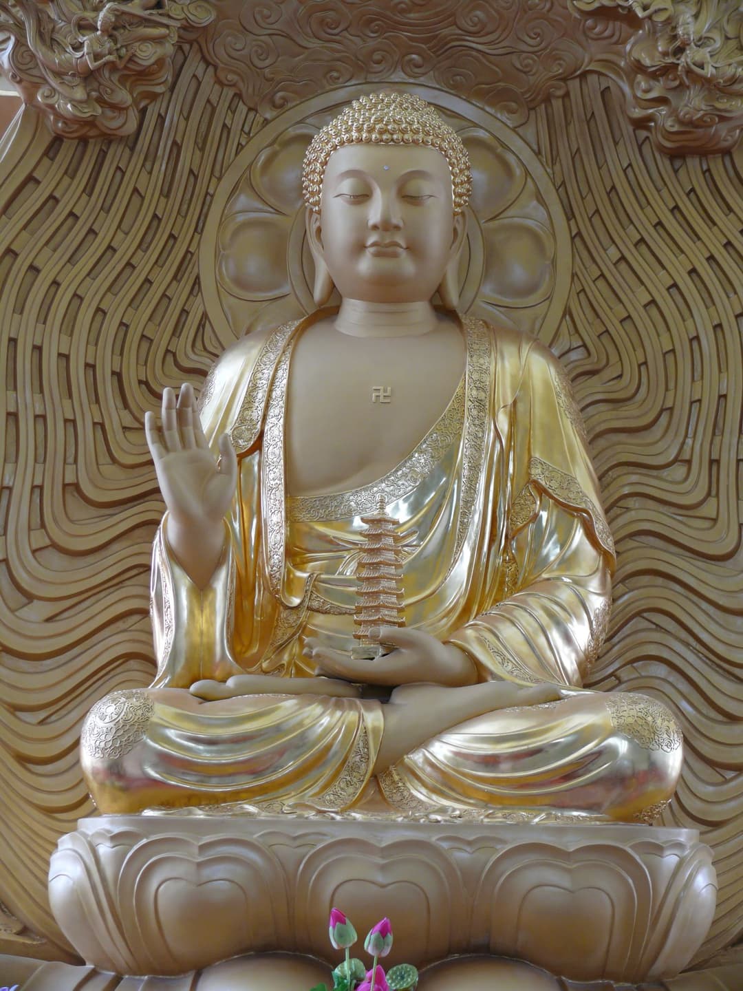 Interior view of a gilded seated Buddha holding a pagoda