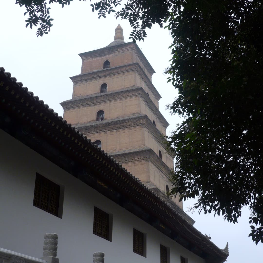 Low-angle view of the Giant Wild Goose Pagoda rising behind a temple hall.