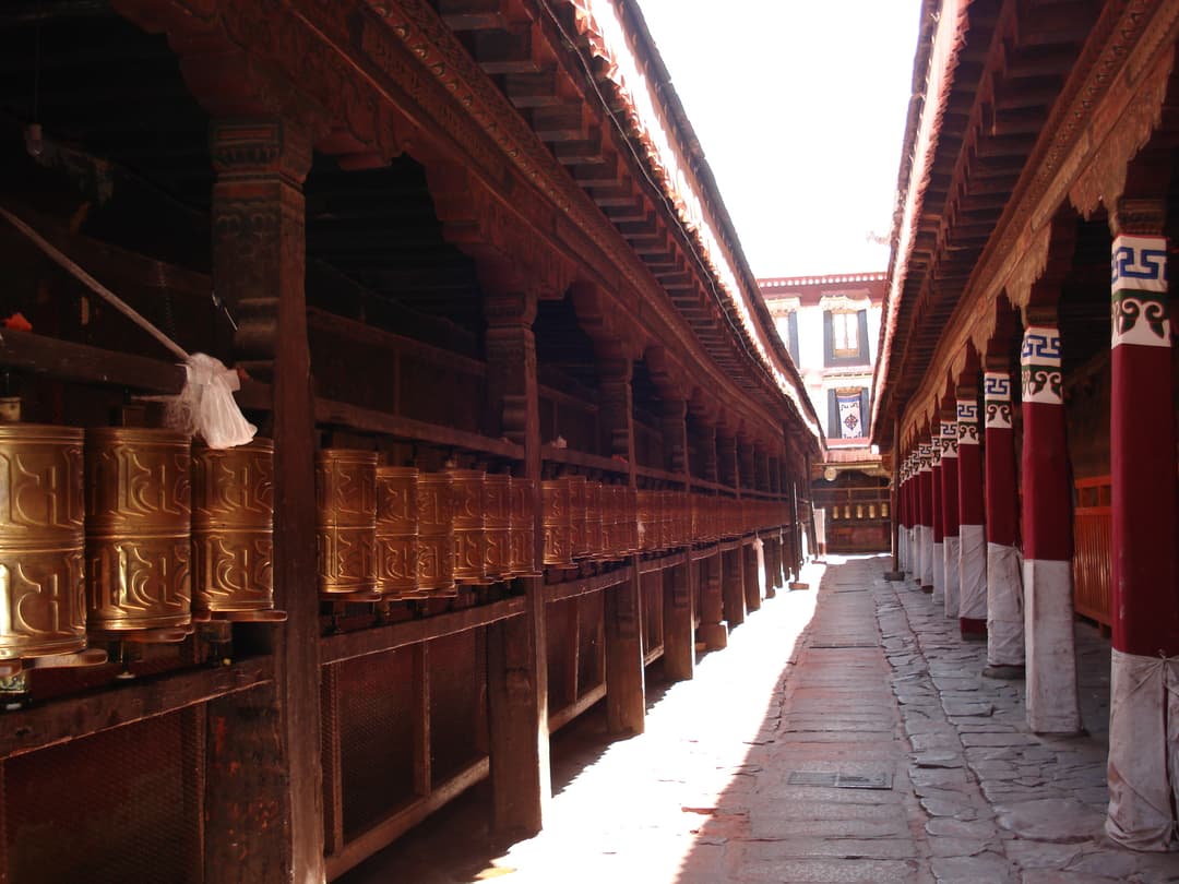 Circumambulation path lined with brass prayer wheels at Jokhang Temple