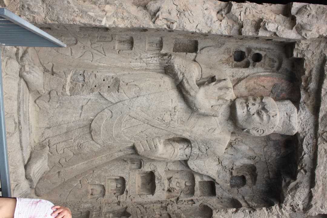 Carved stone Buddhist guardian figure at the Longmen Grottoes.