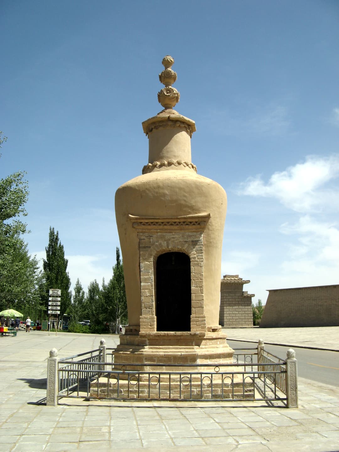 Front view of a Buddhist stupa on the Mogao Caves grounds in bright daylight.