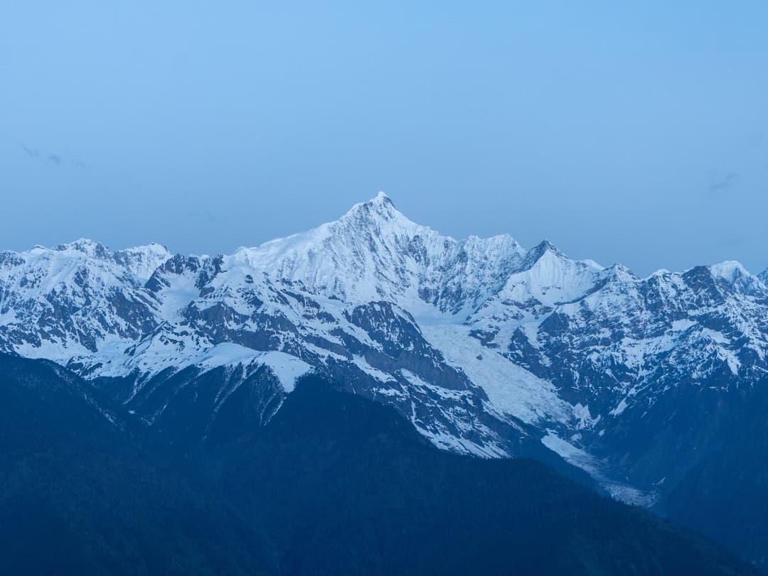 Distant view of snow-capped Mount Kawagarbo at twilight.
