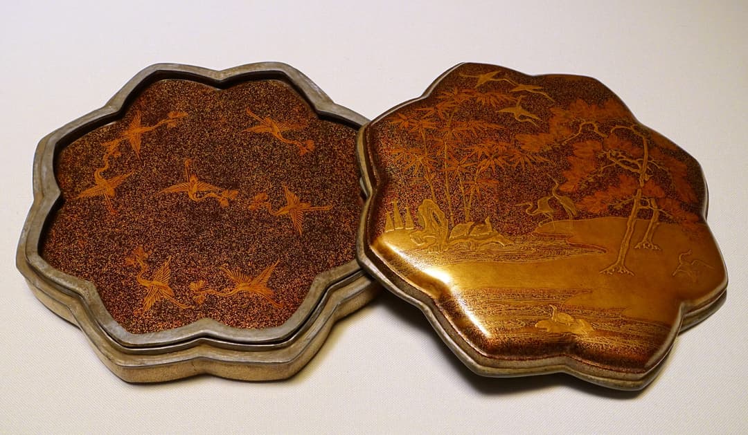 Gold lacquer lobed box and lid decorated with cranes and landscape