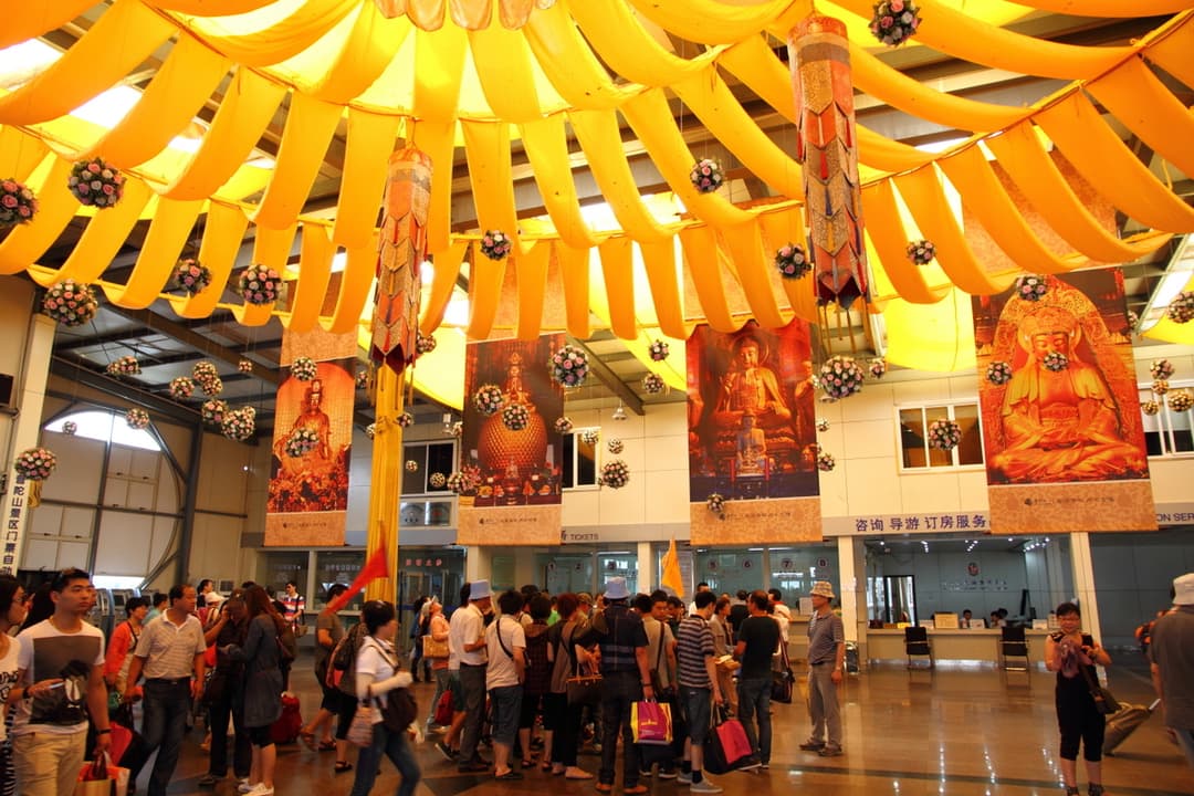 Interior view of a crowded visitor center hall decorated with yellow drapes.