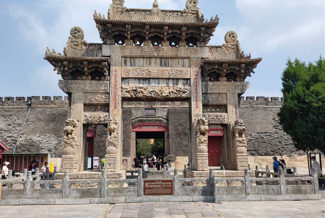 Front view of the intricately carved Dai Miao Archway at Dai Temple, Mount Tai.