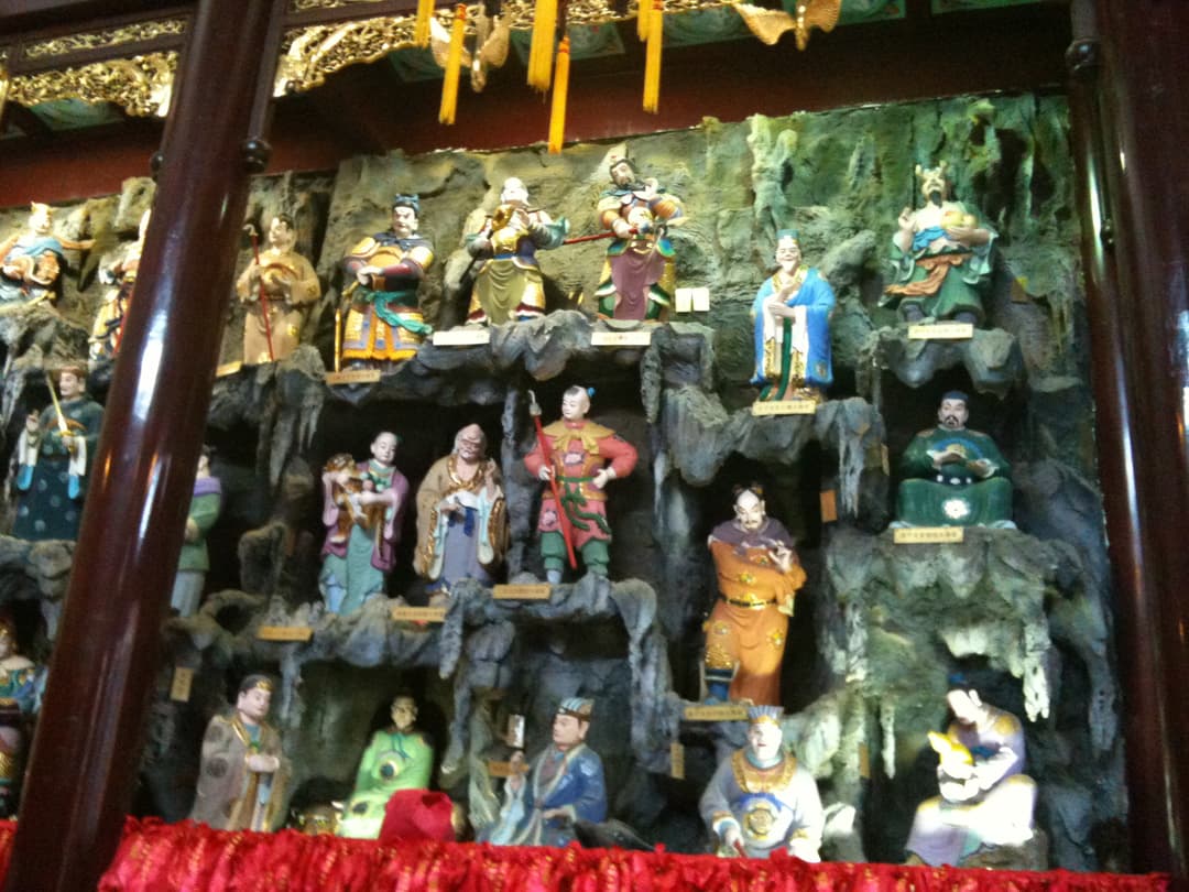 Temple interior: Carved statues on a rock face.