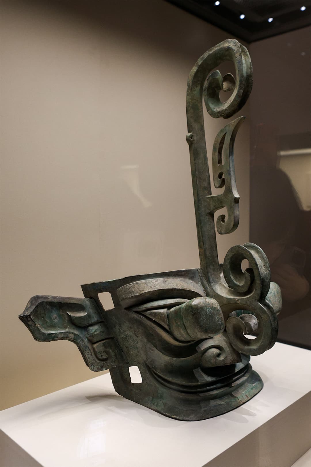 Sanxingdui bronze mask with protruding eyes and ornate forehead crest.