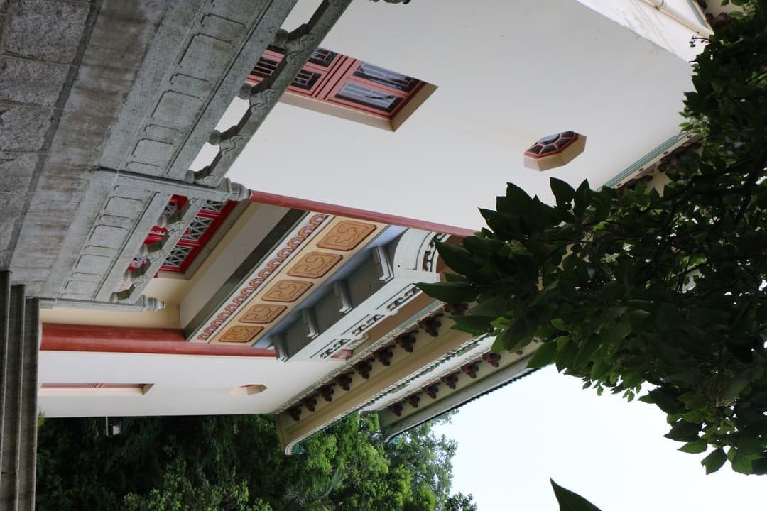 Low-angle view of painted eaves, dougong brackets, and a stone balustrade.