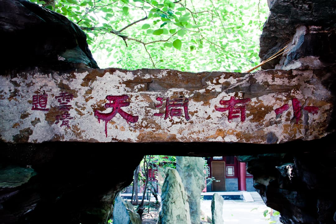 Inscribed rockery archway framing a garden courtyard
