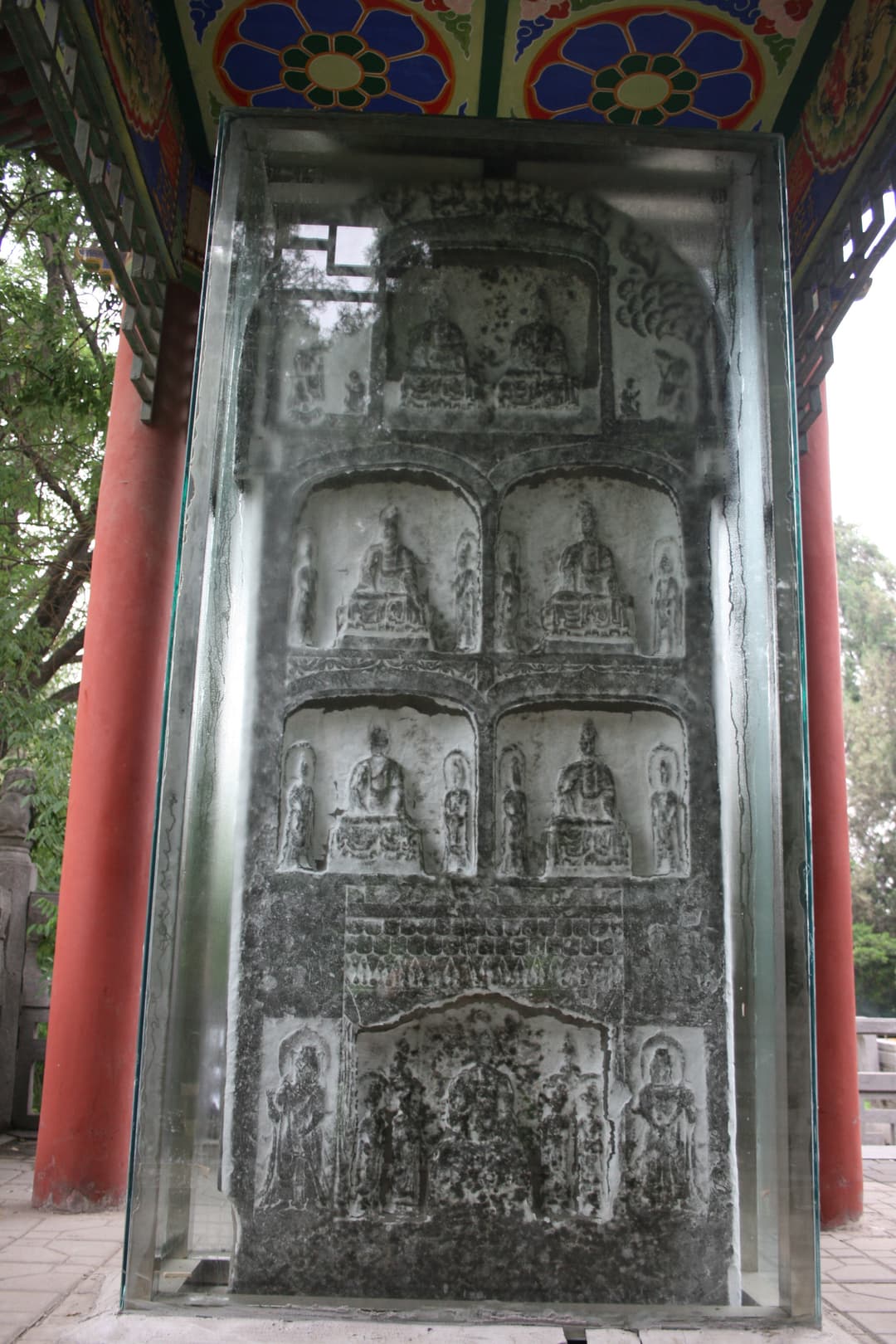 Ancient carved Buddhist stele protected in a glass display pavilion