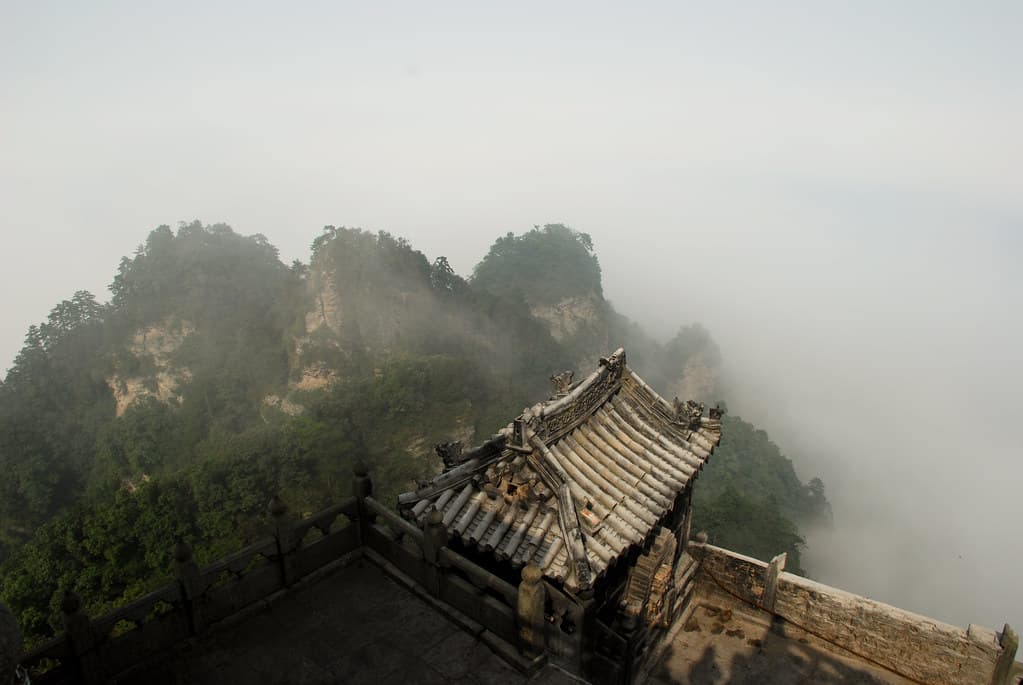 Wudang Mountains: rooftop view overlooking misty peaks.