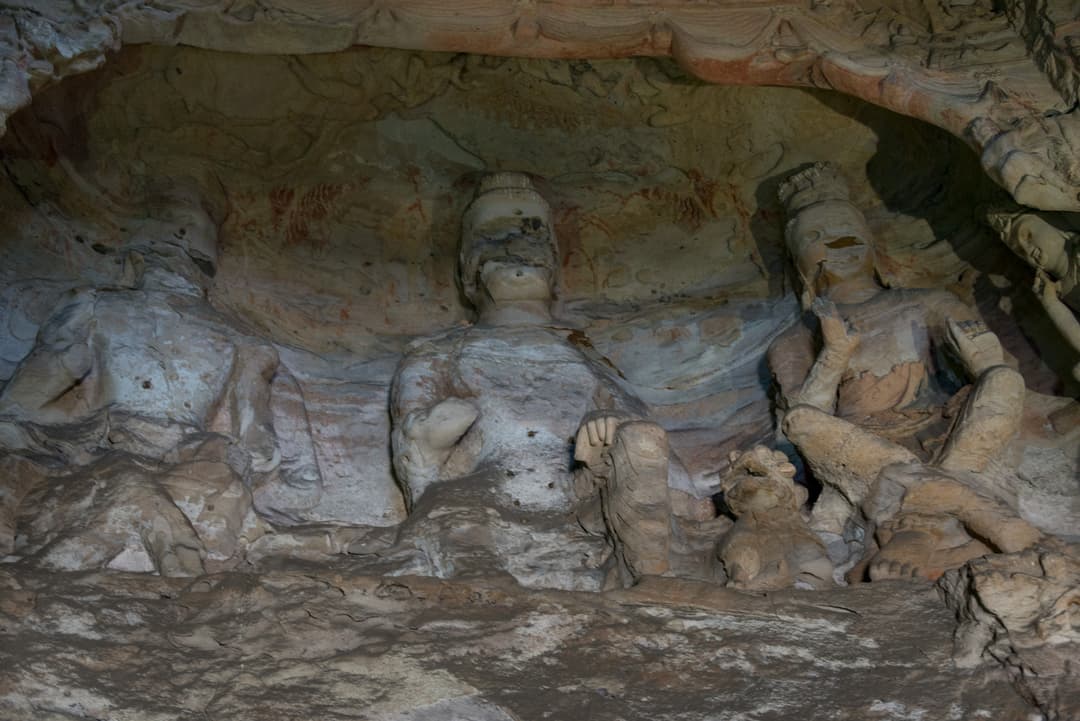 Interior view of rock-cut Buddhist statues inside a Yungang cave niche.