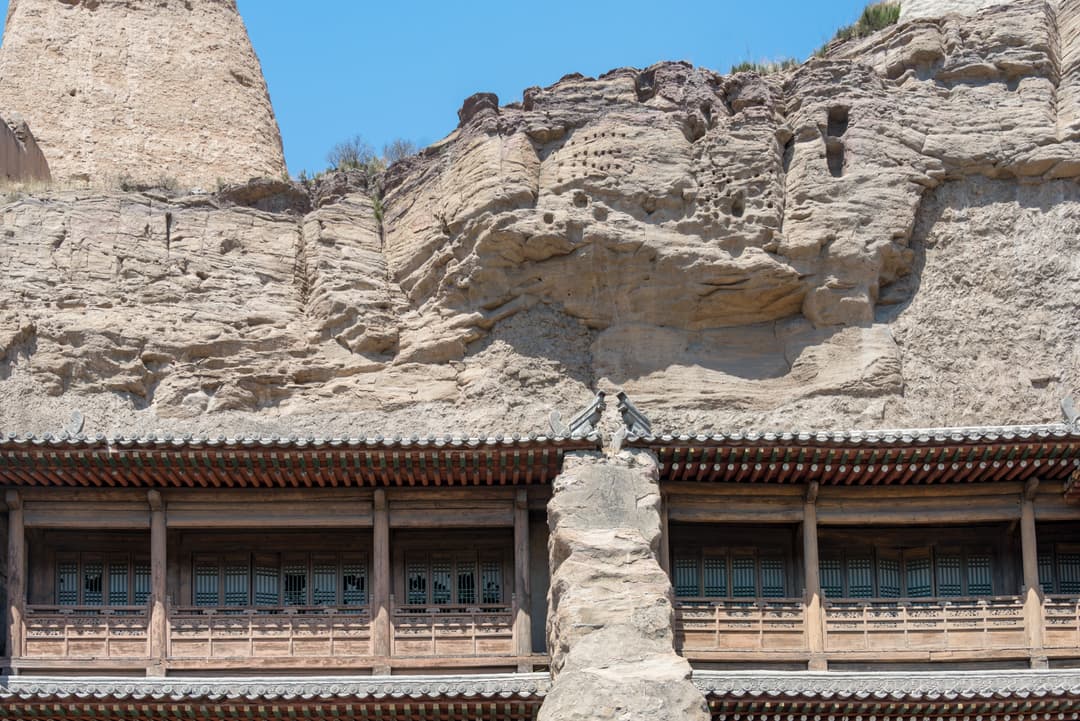 Wooden gallery structure built against the sandstone cliff at Yungang Grottoes.