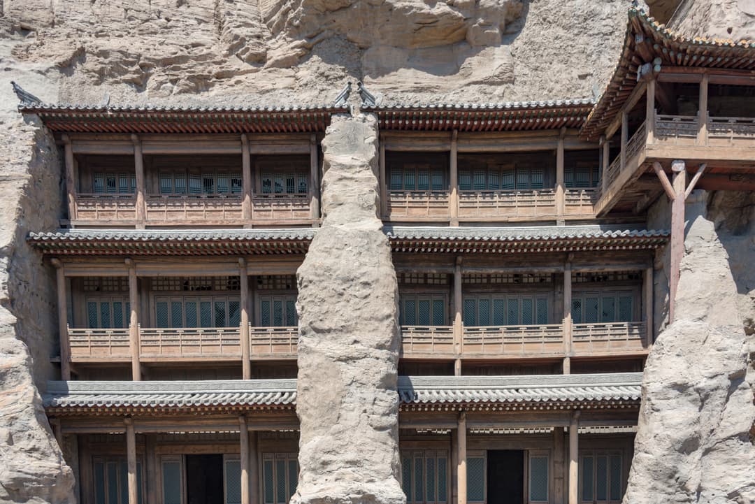 Front view of the multi-story wooden temple facade in daylight.