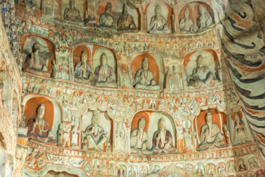Interior detail of painted Buddha niches and carvings at the Yungang Grottoes.