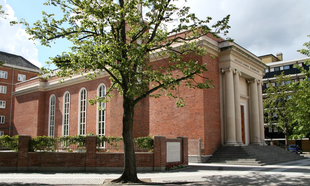 Daytime side view of the brick facade and neoclassical entrance portico.