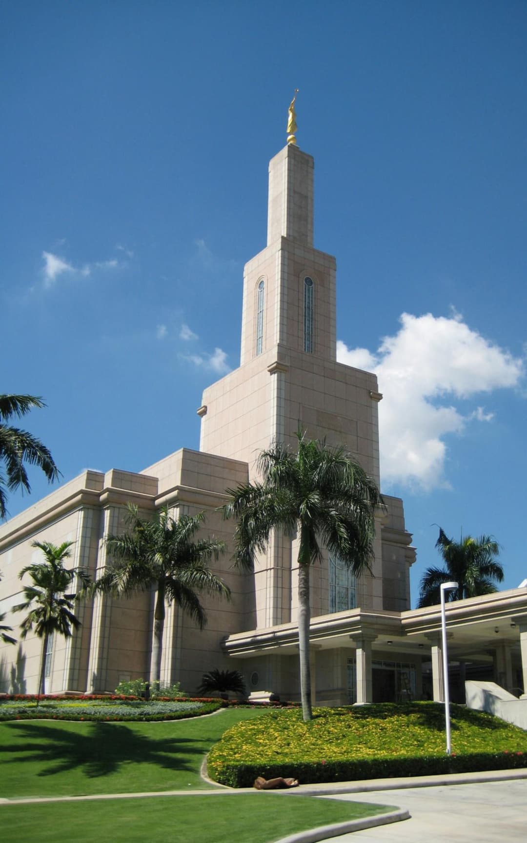Daytime exterior view of the single spire and tropical grounds.