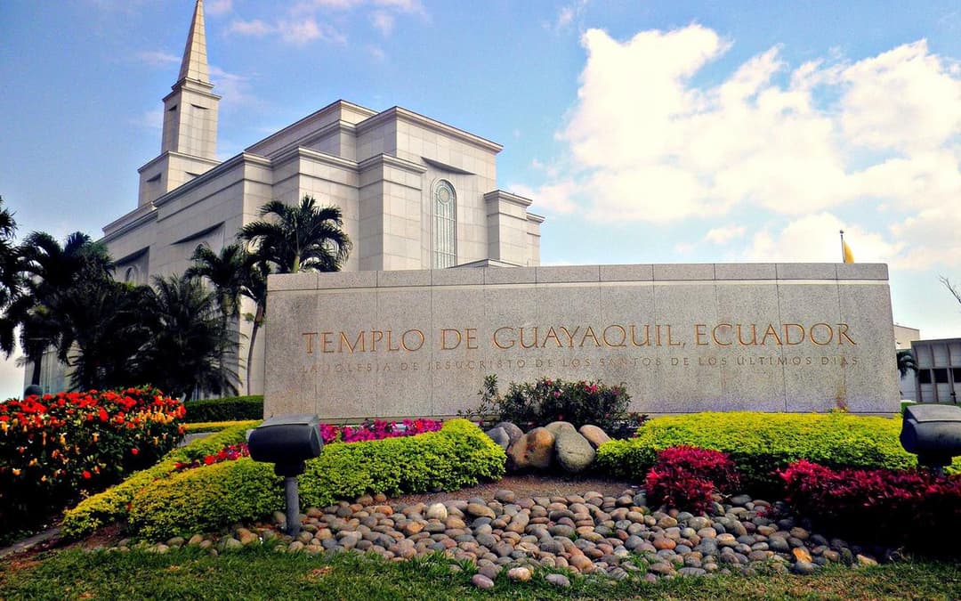 Daytime exterior of Guayaquil Ecuador Temple with spire, sign, and gardens.