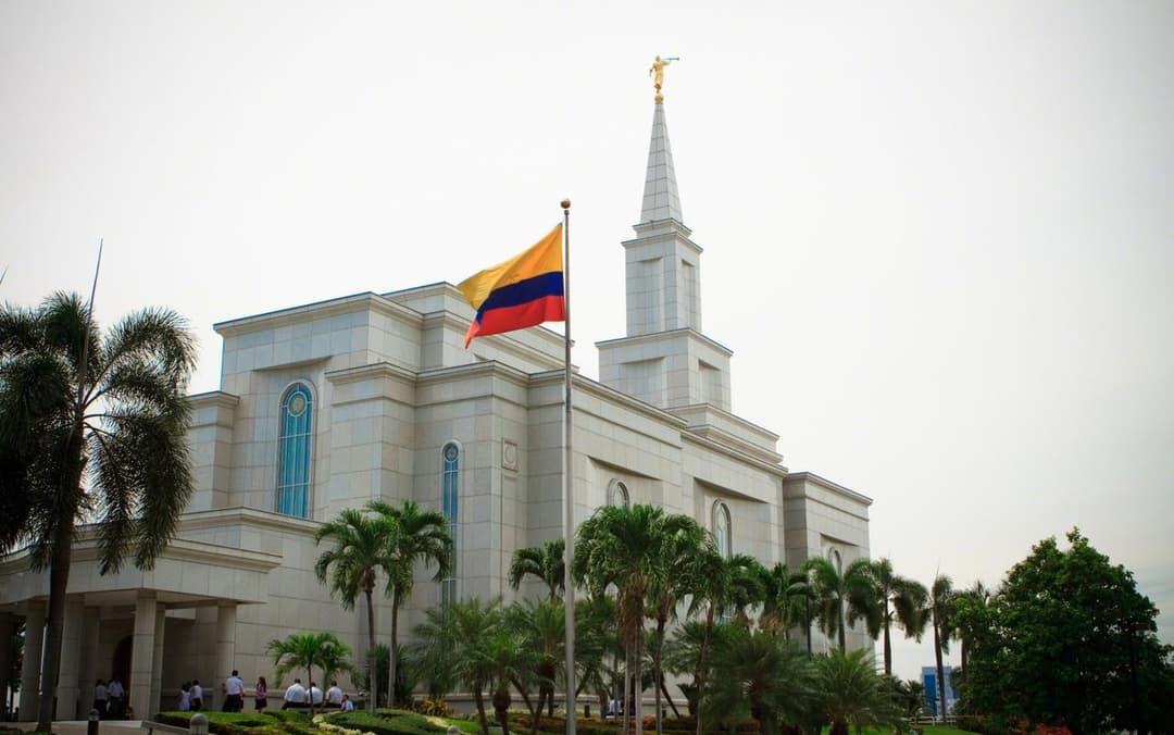 Guayaquil Ecuador Temple exterior with spire, flag, and palms.